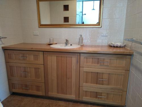 a bathroom with a sink and a mirror at Pine Scrub Beach House in Lughrata