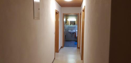 a hallway leading to a bathroom with a sink at Bauernhof Sot Curtegns in Savognin