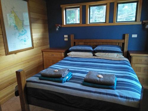 a bedroom with a bed with two bags on it at Pine Scrub Beach House in Lughrata
