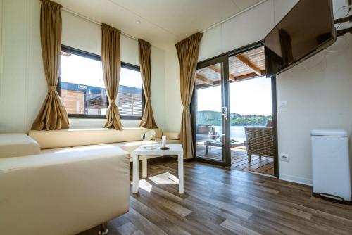 uma sala de estar com um sofá e uma mesa em Olivia Green Camping em Tisno