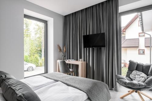 um quarto com uma cama, uma cadeira e uma janela em Villa 33 em Zakopane