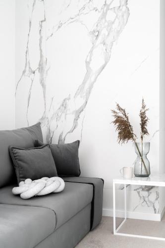 a couch in a living room with a wall at Villa 33 in Zakopane