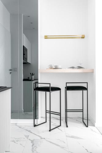 a kitchen with a counter with two black stools at Villa 33 in Zakopane