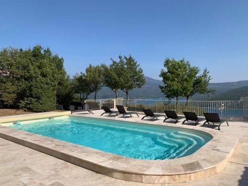 une piscine avec des chaises longues et une piscine dans l'établissement Ferme Para Lou, à Sainte-Croix-de-Verdon