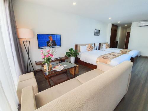 a hotel room with two beds and a living room at REIWA INN APARTMENT in Hanoi