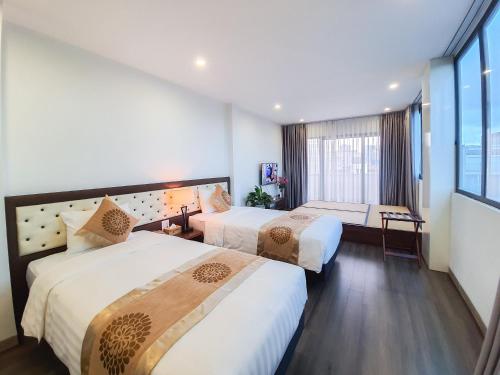 a hotel room with two beds and a window at REIWA INN APARTMENT in Hanoi