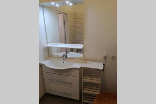 La salle de bains est pourvue d'un lavabo et d'un miroir. dans l'établissement Amstetten Apartment, à Amstetten