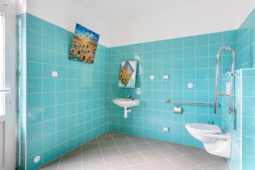 niebieska łazienka z toaletą i umywalką w obiekcie Farma Slunečný Dvůr w mieście Hermanuv Mestec