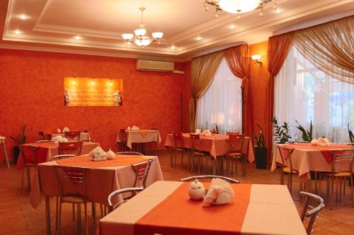 un restaurante con mesas y sillas con paredes rojas en Meridian-Yug Hotel, en Krasnyy Kolos