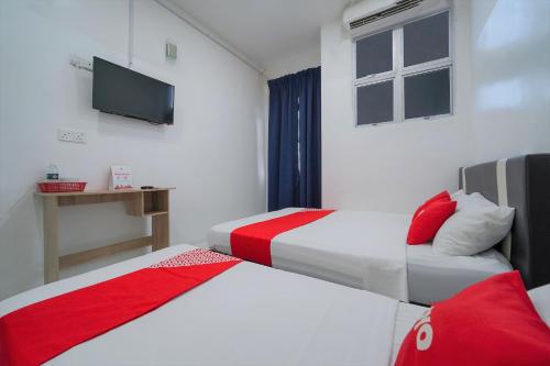 a hotel room with two beds and a flat screen tv at OYO 89820 Sp Berlian Inn in Sungai Petani