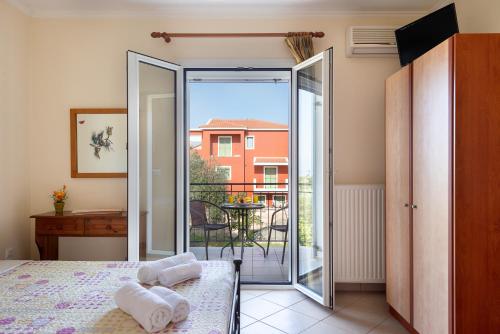 a bedroom with a bed and a sliding glass door at Vista Verde Studios, Svoronata in Svoronata