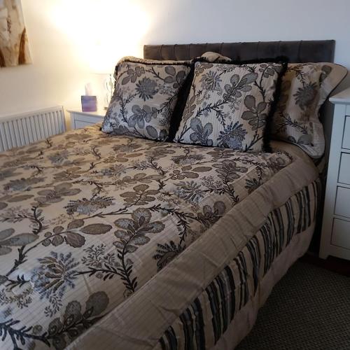 - un lit avec une couverture et des oreillers dans l'établissement Hooton Apartment 1 bed, à Kilnhurst