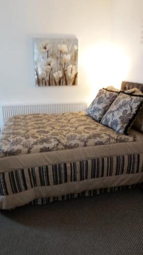 uma cama num quarto com um quadro na parede em Hooton Apartment 1 bed em Kilnhurst