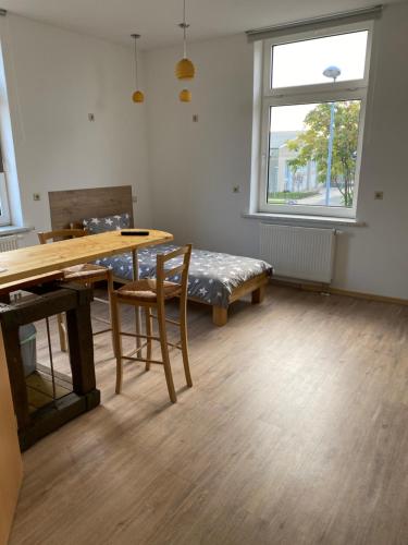 um quarto com uma mesa, um banco e uma janela em Zollzeche Stadtwohnungen em Staßfurt