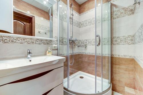 uma casa de banho com um chuveiro e um lavatório. em Апартаменты на канале Грибоедова em São Petersburgo