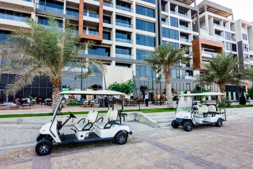 two golf carts parked in front of a building at Boudl Al Jubail in Al Jubail