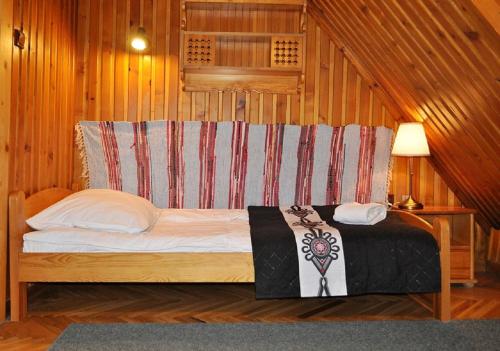 a bed in a room with wooden walls at Willa Orla in Zakopane