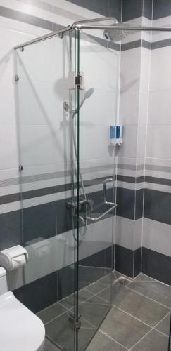 La salle de bains est pourvue d'une douche en verre et de toilettes. dans l'établissement Garden House Côn Đảo, à Côn Son