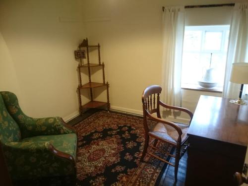 a living room with two chairs and a table and a window at Low House Farm North, Troutbeck, Windermere in Windermere