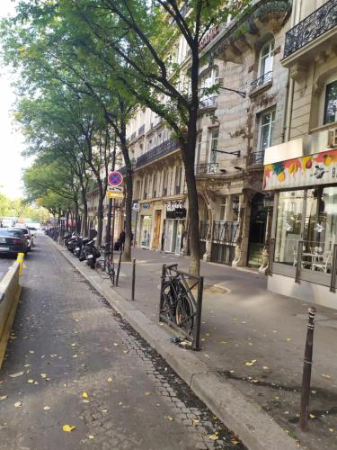a city street with trees and cars parked on the street at Elysées Ceramic in Paris