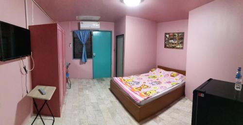 ein kleines rosafarbenes Schlafzimmer mit einem Bett und einem TV in der Unterkunft อารมย์ดี อพาทเม้นท์ ขอนแก่น in Ban Nong Waeng