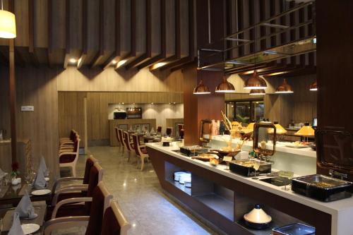 a restaurant with a long counter and some chairs at Hotel Madhuban in Dehradun
