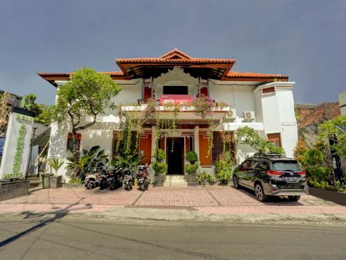 デンパサールにあるOYO 3850 Bali Kepundung Hotelの二輪車の家の前に駐車した車