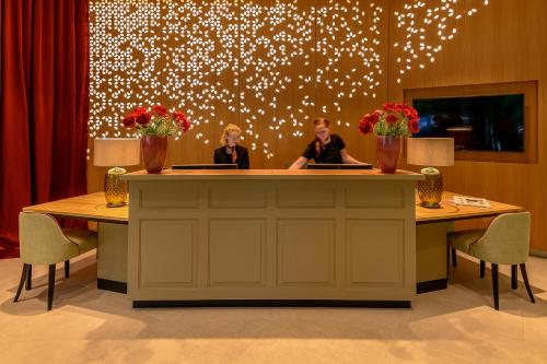 two people sitting at a counter in a room at Parkhotel Rothof in Munich