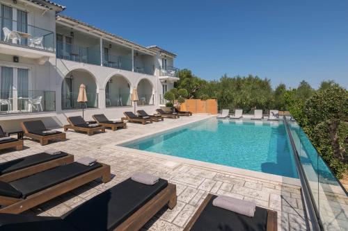 a swimming pool with lounge chairs and a hotel at Litore Luxury Living in Laganas