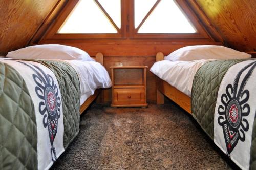 two beds in a room with two windows at Willa Orla in Zakopane