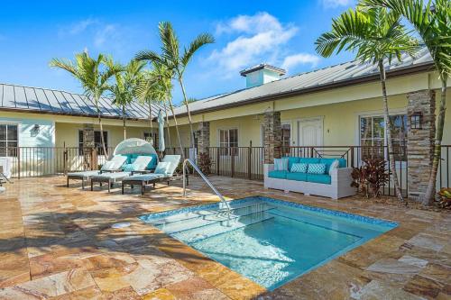 a patio with a pool and a house with palm trees at Bermuda Bungalows (Tropical Island Getaway) in West Palm Beach