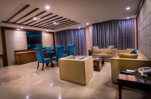a living room with a couch and chairs and a table at Hotel Madhuban in Dehradun
