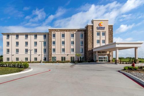 a large white building with a gas station at Comfort Inn & Suites in Waller