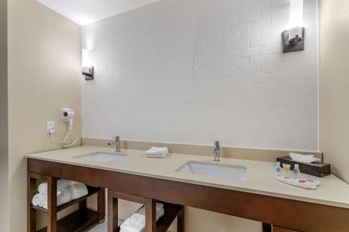 a bathroom with two sinks and a large mirror at Comfort Inn & Suites in Waller