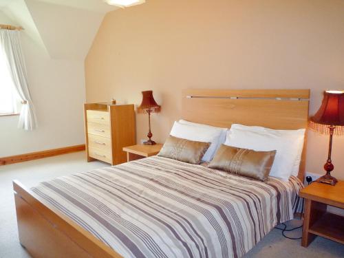 a bedroom with a large bed with two pillows at Cois Chnoic Holiday Home Dingle in Dingle