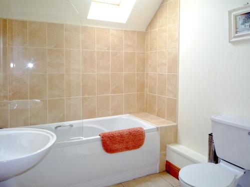 a bathroom with a tub and a sink and a toilet at Cois Chnoic Holiday Home Dingle in Dingle
