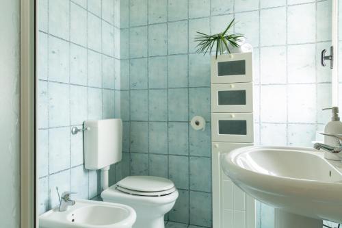 a bathroom with a white toilet and a sink at Sea View Home -Bilocale Angolo Cottura Vista Mare 4 pax in Albinia