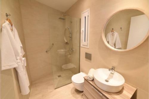 a bathroom with a sink and a shower and a mirror at Bella Veranda in Anemómylos