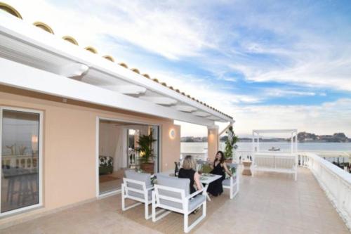 two people sitting on the balcony of a house at Bella Veranda in Anemómylos