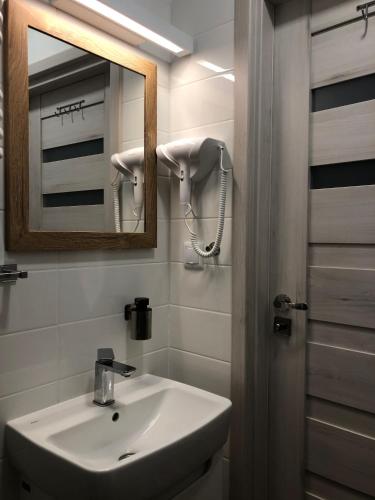 a bathroom with a sink and a mirror at Zamkowy Apartament in Lublin
