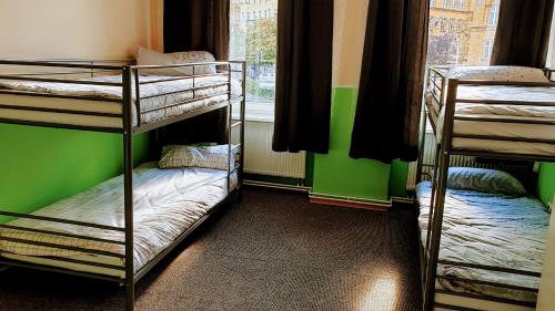 two bunk beds in a room with a green wall at Mir hostel in Berlin