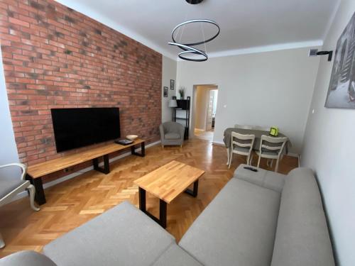 ein Wohnzimmer mit Sofa und Ziegelwand in der Unterkunft Zamkowy Apartament in Lublin