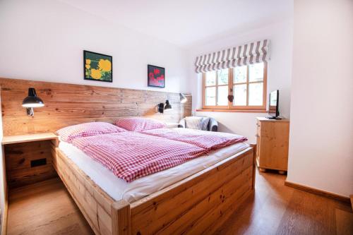 a bedroom with a large bed with a wooden wall at Ferienwohnung Königsleiten 111 in Königsleiten
