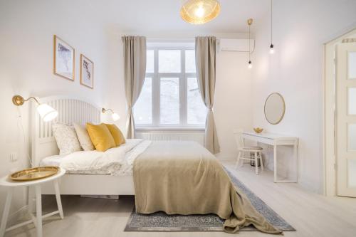 ein weißes Schlafzimmer mit einem Bett und einem Fenster in der Unterkunft BpR LYNX Home with A/C in Budapest