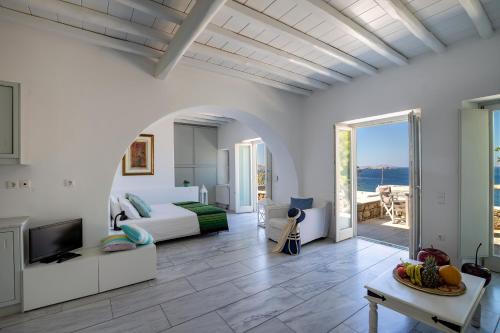 a bedroom with a bed and a living room with a television at Olia Hotel in Tourlos
