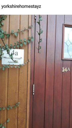 una porta di legno con un cartello sul lato di Hooton Apartment 1 bed a Kilnhurst