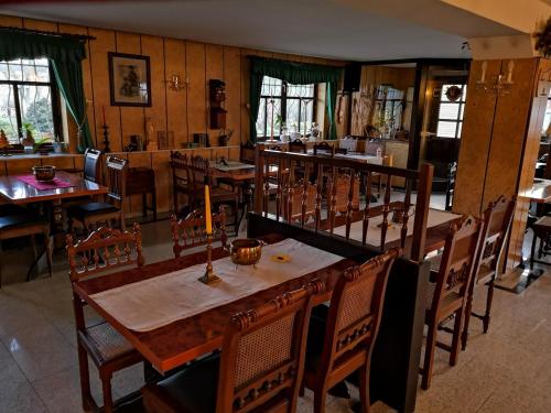uma sala de jantar com mesas e cadeiras de madeira em Windmühlenhof em Dittmannsdorf