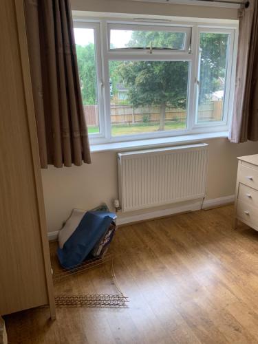 a room with two large windows and a wooden floor at 75ers private room in Cheltenham