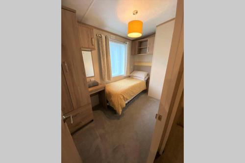 a small bedroom with a bed and a window at Cotswold Lodge - Pet Friendly in South Cerney