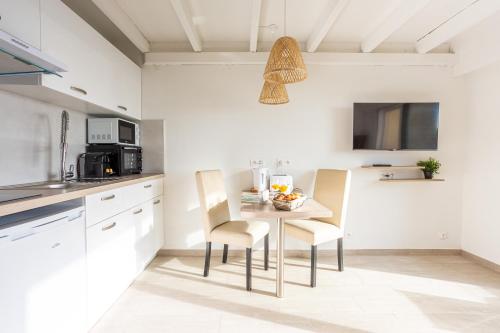 a kitchen with a table and chairs in a room at Appartement Marineland Sea View in Antibes